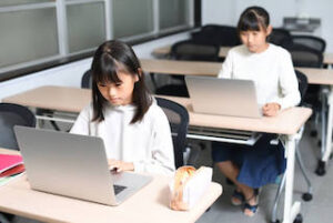 教室でオンライン授業を受ける女子児童